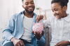 a man and a child putting money into a piggy bank